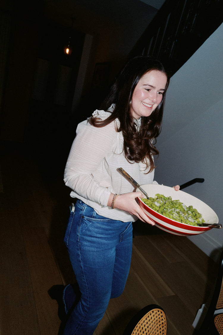 woman carrying pasta in bowl