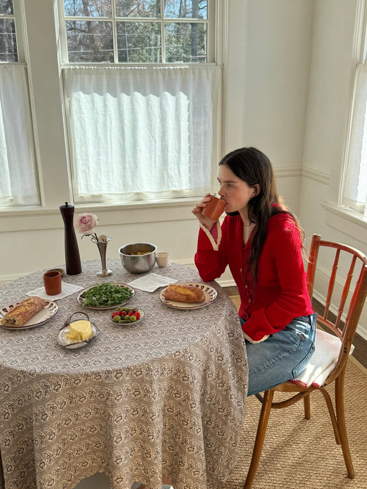 woman sitting at table drinking coffee