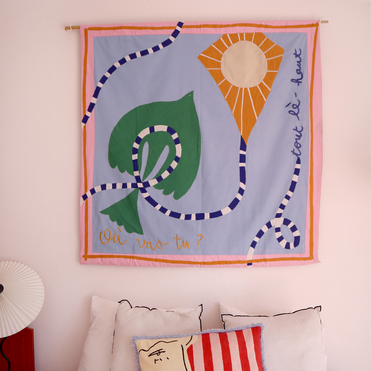 quilt in purple and pink hues on pink wall