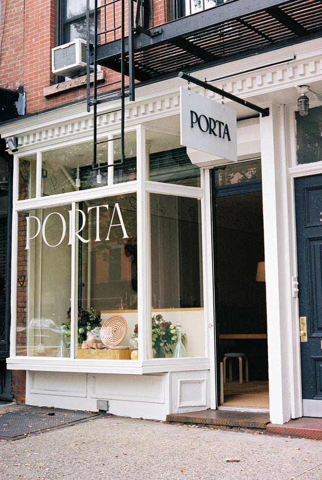 exterior store front with PORTA on the window and sign hanging above the door