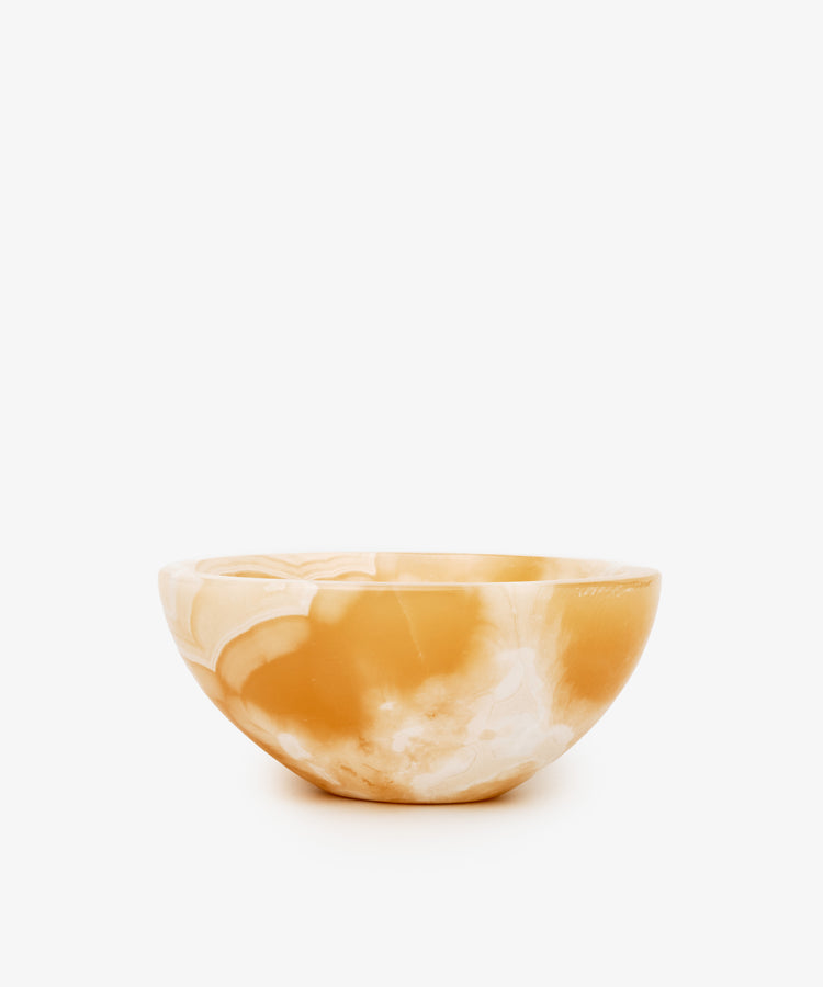 An alabaster catchall bowl of white and deep yellow coloring, ideal for organizing small objects.