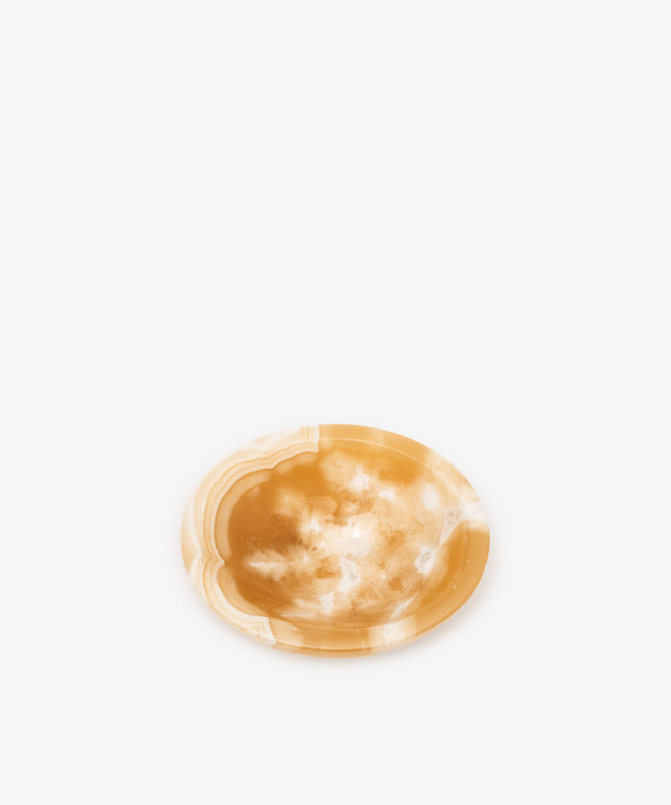 An alabaster catchall bowl of white and deep yellow coloring, ideal for organizing small objects.