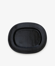 A large rectangular platter, crafted from ceramic and finished in black, is centered on a plain white background, showcasing the modern elegance of a contemporary serving piece.