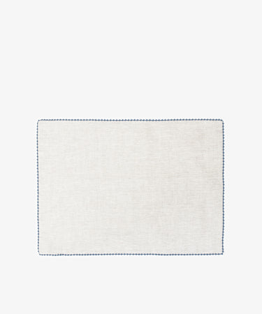 The Nico Placemat, Set of 6, features rectangular, light-colored linen with a simple blue hand-stitched edge—ideal for elegant table decor. Displayed on a white background.