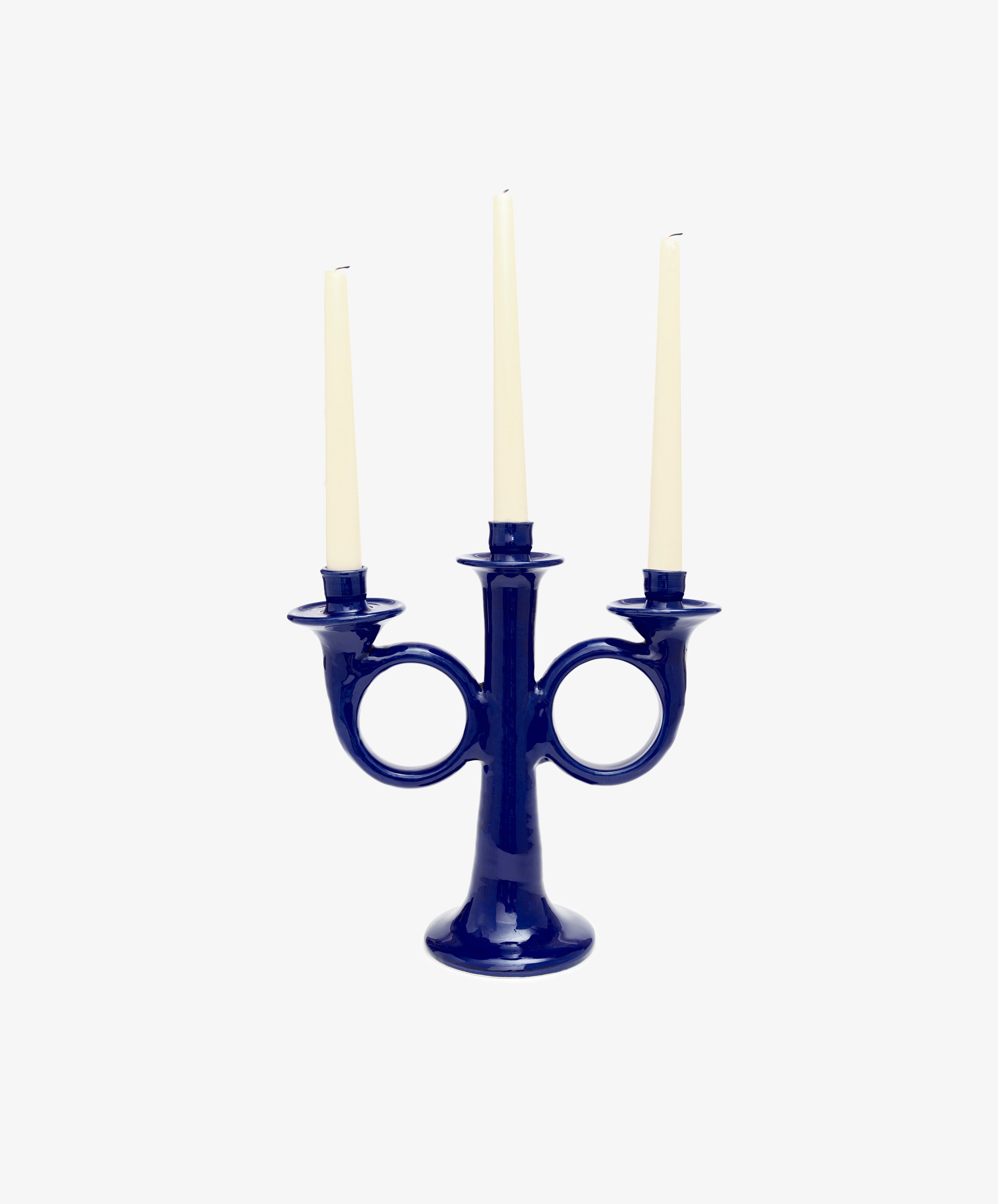 Loretta Candelabra. Dark blue glazed ceramic candle holder with three white taper candles.