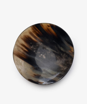 The Curiosity Bowl 10 is a round, shallow decorative piece with a marbled black, brown, and beige design on white—a stylish accent for any collection.