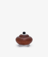 Curiosity Box 11: A small, round African wood box with a lid and knob handle, set on three short legs against a plain white background.