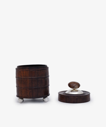 Curiosity Box 8—a small, barrel-shaped African wood box with metal feet—is shown open, its lid set to the right, against a plain white background.