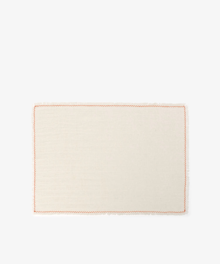 The Filial Placemat, Set of 6, features rectangular cream-colored cloth placemats with a simple orange branch stitch border, ideal for elegant tabletop decor. Shown on a plain white background.