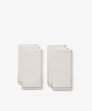 Six neatly folded white Filial Napkins with delicate branch stitch detailing along the edges, arranged in two pairs on a plain white tabletop.