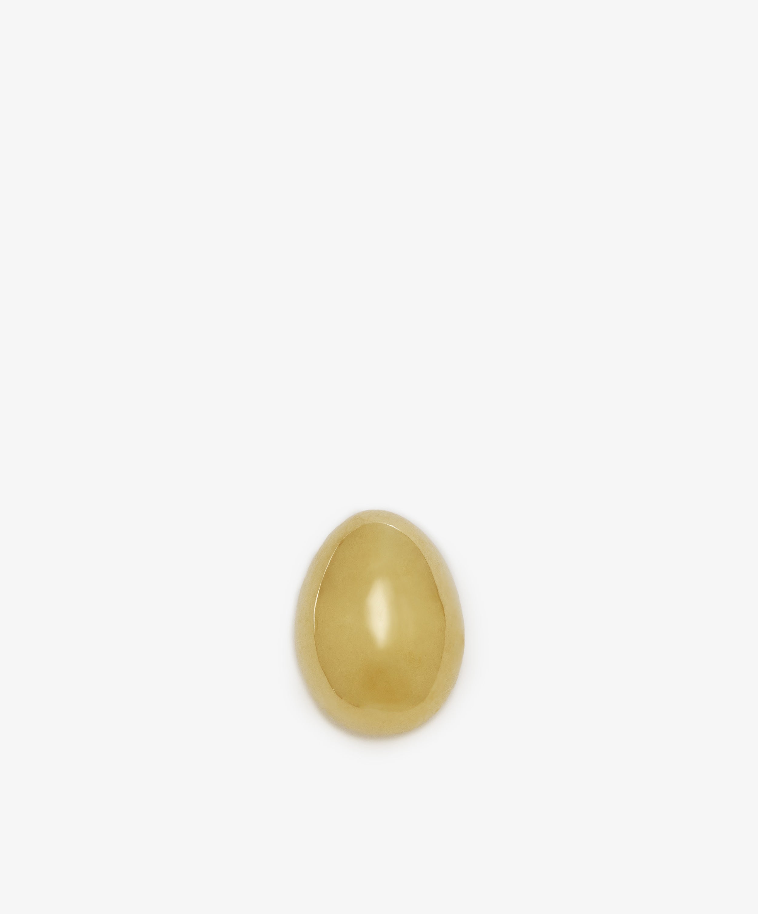 A single Egg Paperweight in small gold brass by Auböck Vienna sits centered on a plain white background—a sculptural desk accessory with enduring style.