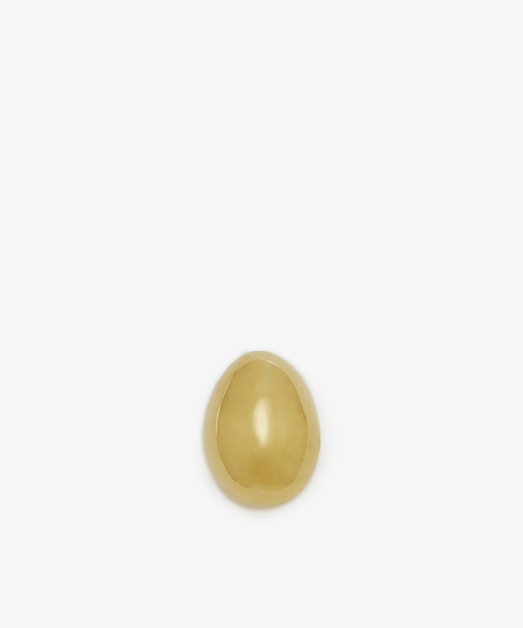 A single Egg Paperweight in small gold brass by Auböck Vienna sits centered on a plain white background—a sculptural desk accessory with enduring style.