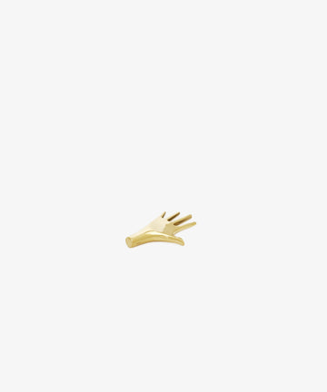 The Hand Paperweight, inspired by Viennese modernism, is a small gold object shaped like a hand with five outstretched fingers, designed to serve as a sculptural paperweight on any desktop.