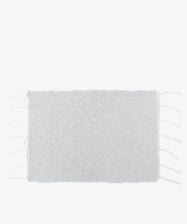 The Gaia Placemat, Set of 6, features rectangular light gray woven mats handwoven in Portugal from recycled fabric with short fringe on the shorter edges, shown against a plain white background.