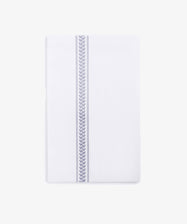 The Striped Tea Towel is a white, 100% cotton rectangular towel with a single blue chevron stripe running vertically near one edge, set against a plain white background.