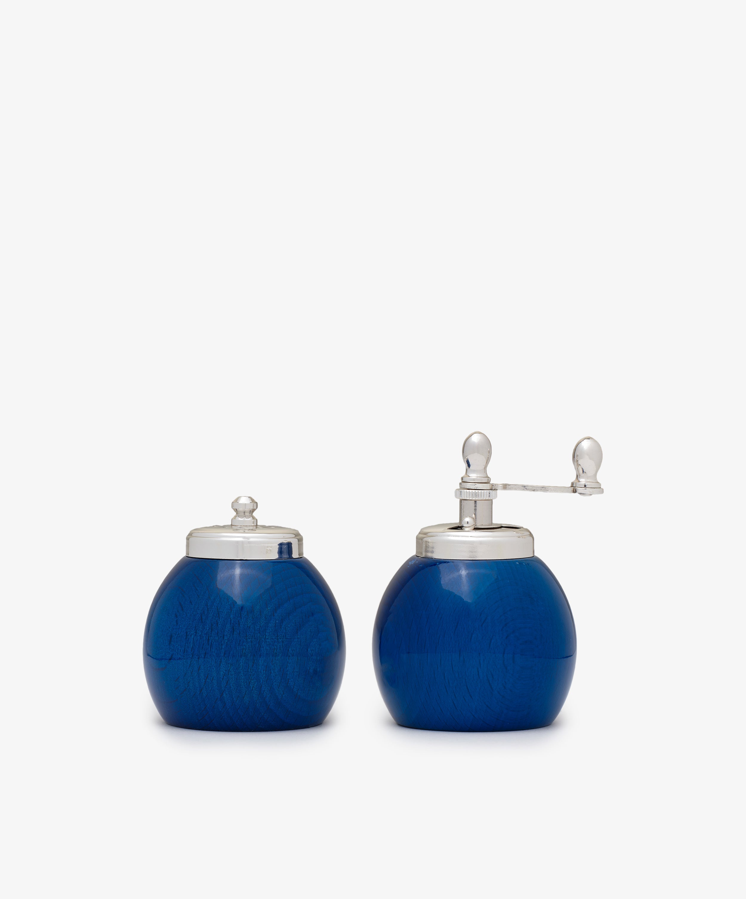 The Theo Pepper Mill and Salt Shaker set features two round, blue containers with silver lids; the right one has a grinder, while the left serves as a shaker—both exhibit classic Italian design.