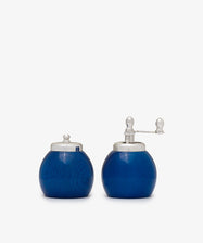 The Theo Pepper Mill and Salt Shaker set features two round, blue containers with silver lids; the right one has a grinder, while the left serves as a shaker—both exhibit classic Italian design.