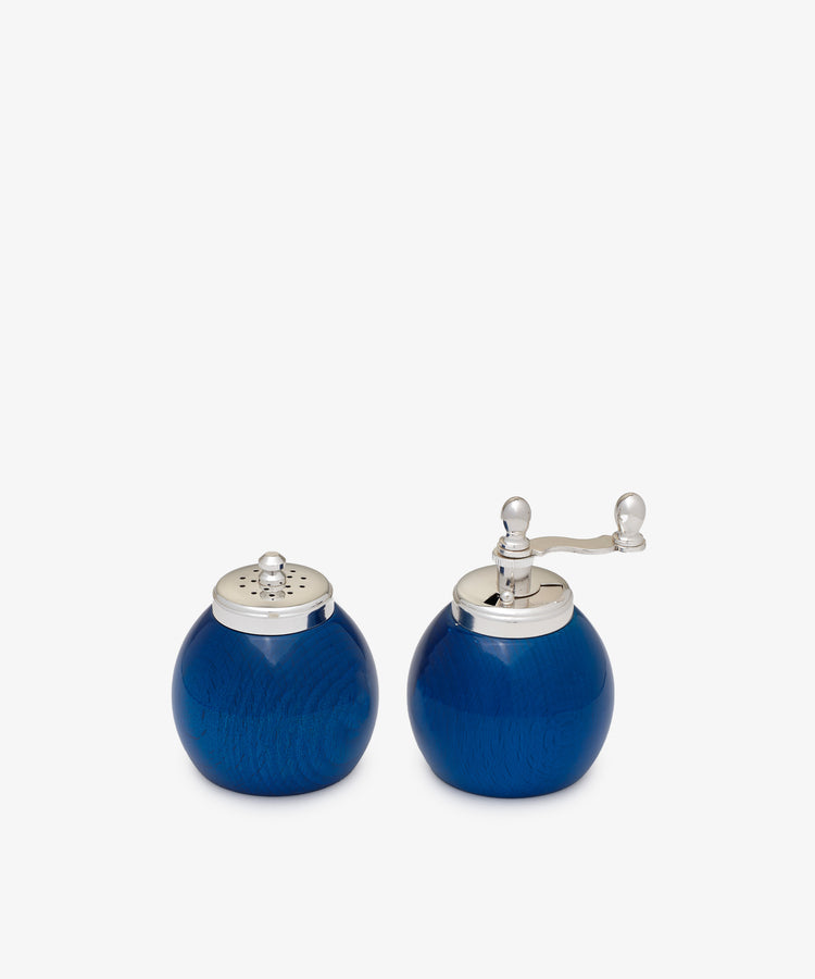 The Theo Pepper Mill and Salt Shaker, both in blue with silver tops, display a sleek Italian design and efficient grinding mechanism, shown side by side against a plain white background.