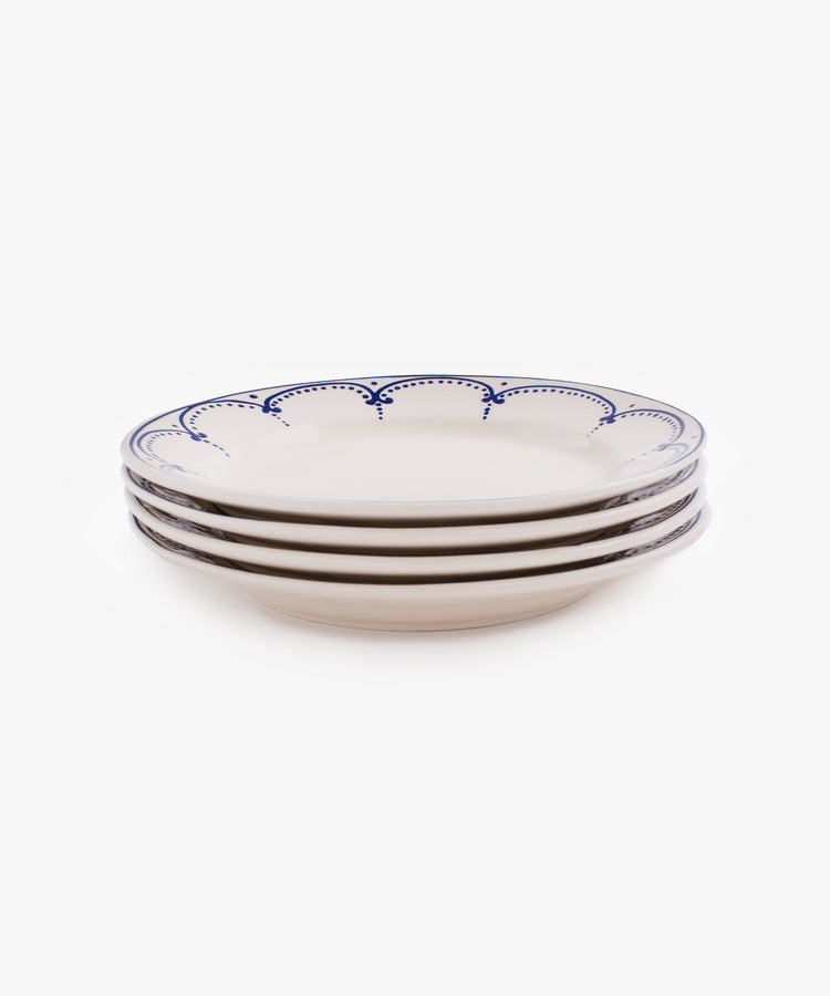 Stack of four white glazed ceramic Arco dinner plates.