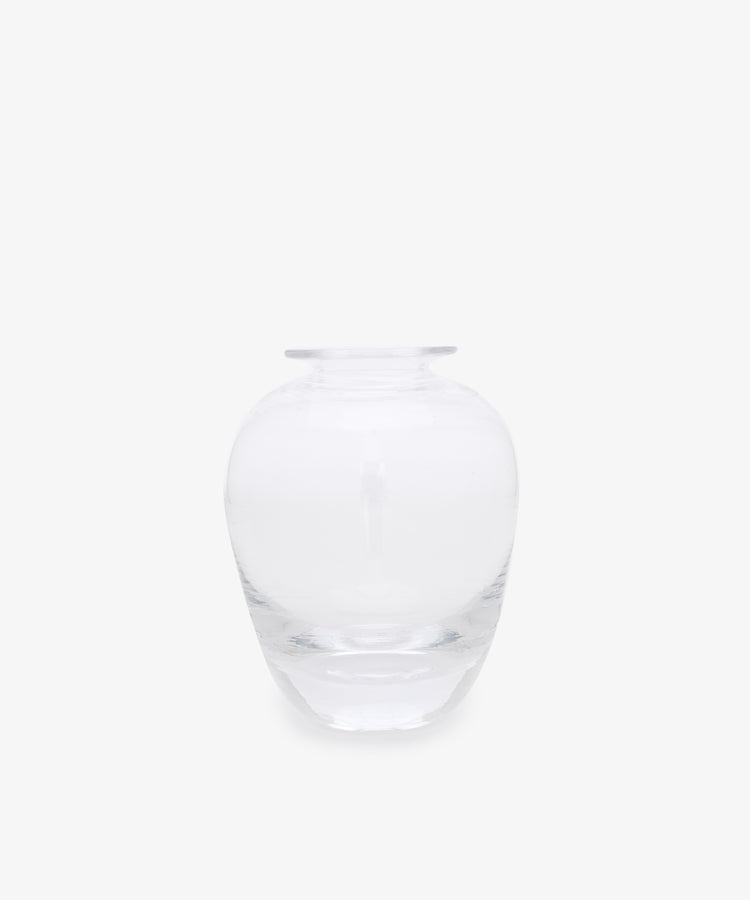 The Gem Bud Vase is a hand blown clear glass vase featuring a wide, round body and a short, narrow neck, shown against a plain white background.