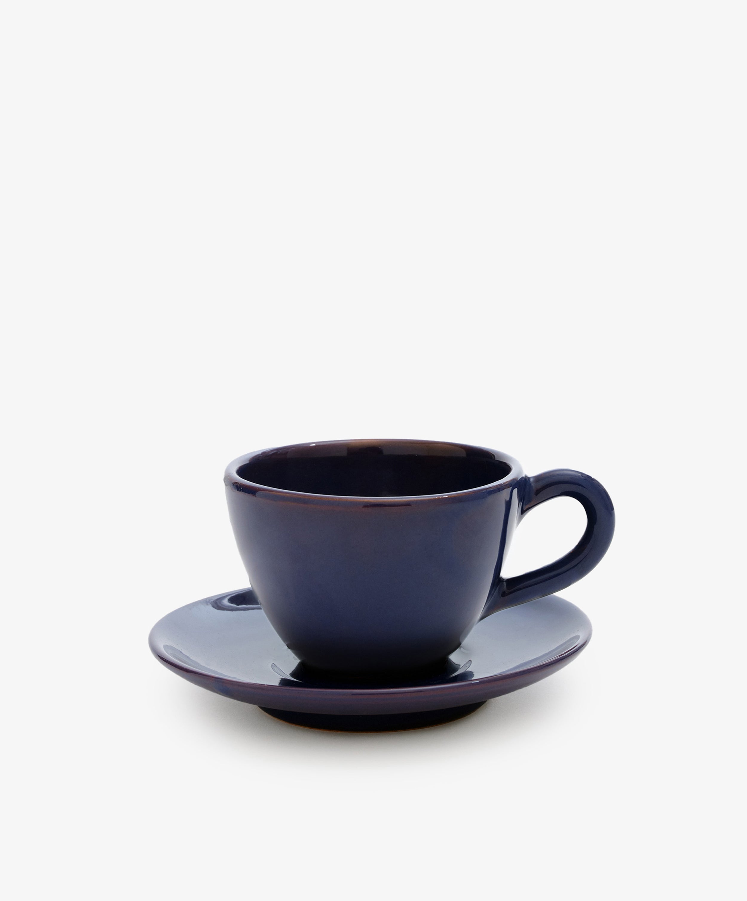 The Guido Coffee Set features a dark blue ceramic breakfast cup placed on a matching saucer, set against a plain white background.