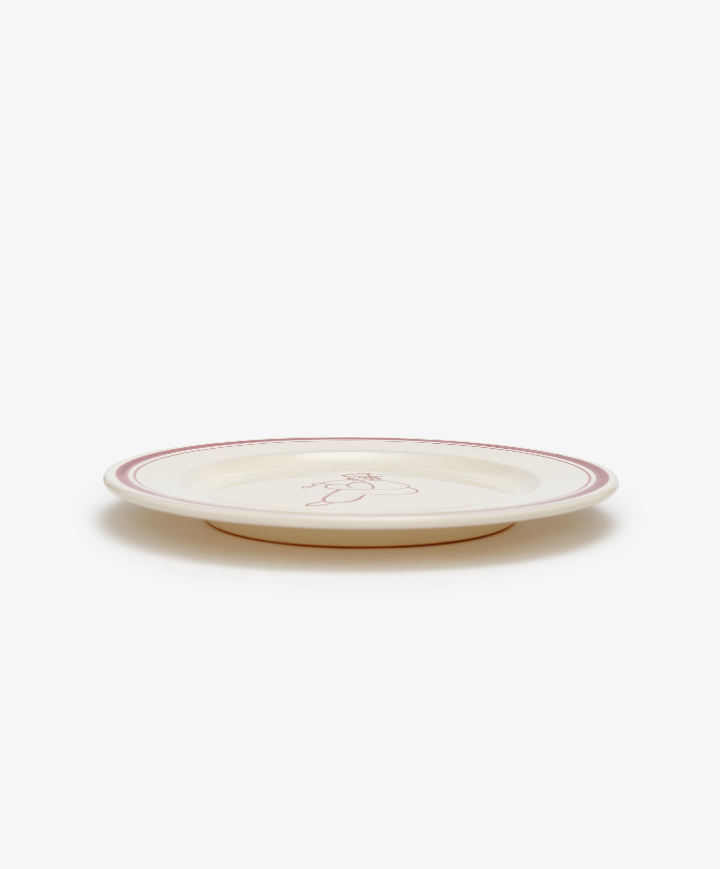The Folk Dinner Plate, Farmer features a cream ceramic design with a pink rim and a hand-painted line drawing of a bear in the center, adding charm to any tableware collection. Shown against a white background.