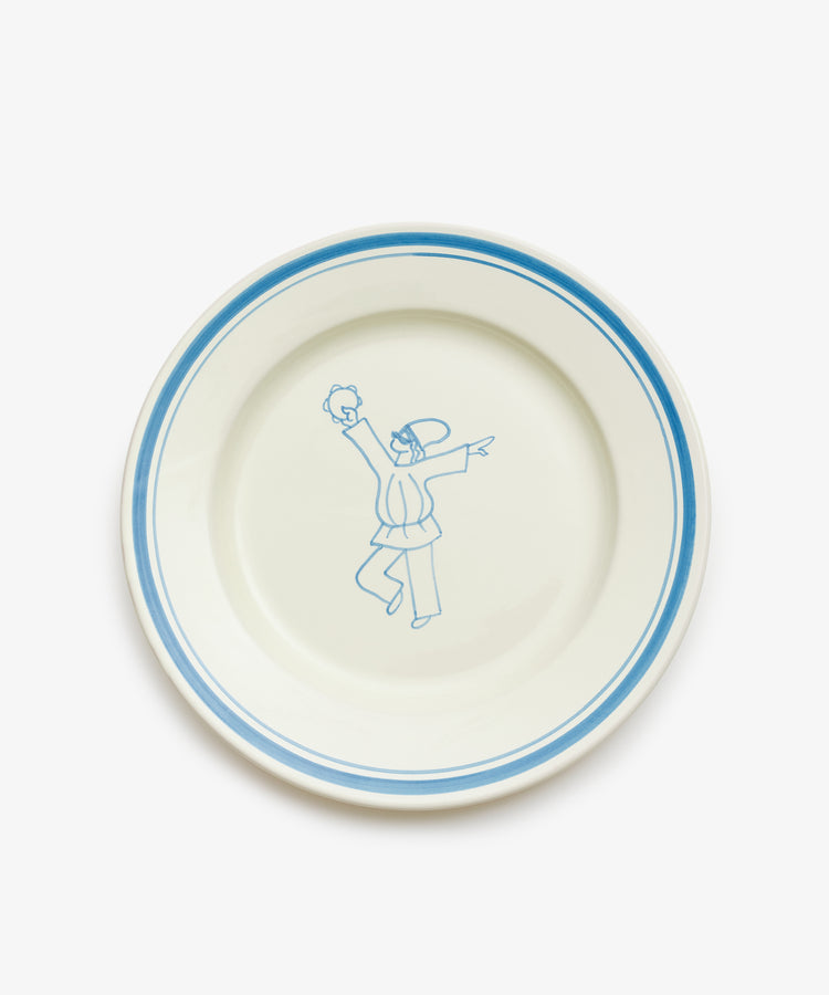 The Folk Dinner Plate, Jester, is a white ceramic plate with a blue rim and a hand-painted blue sketch of two people in the center, designed by an Italian ceramist to bring artistic charm to your table.