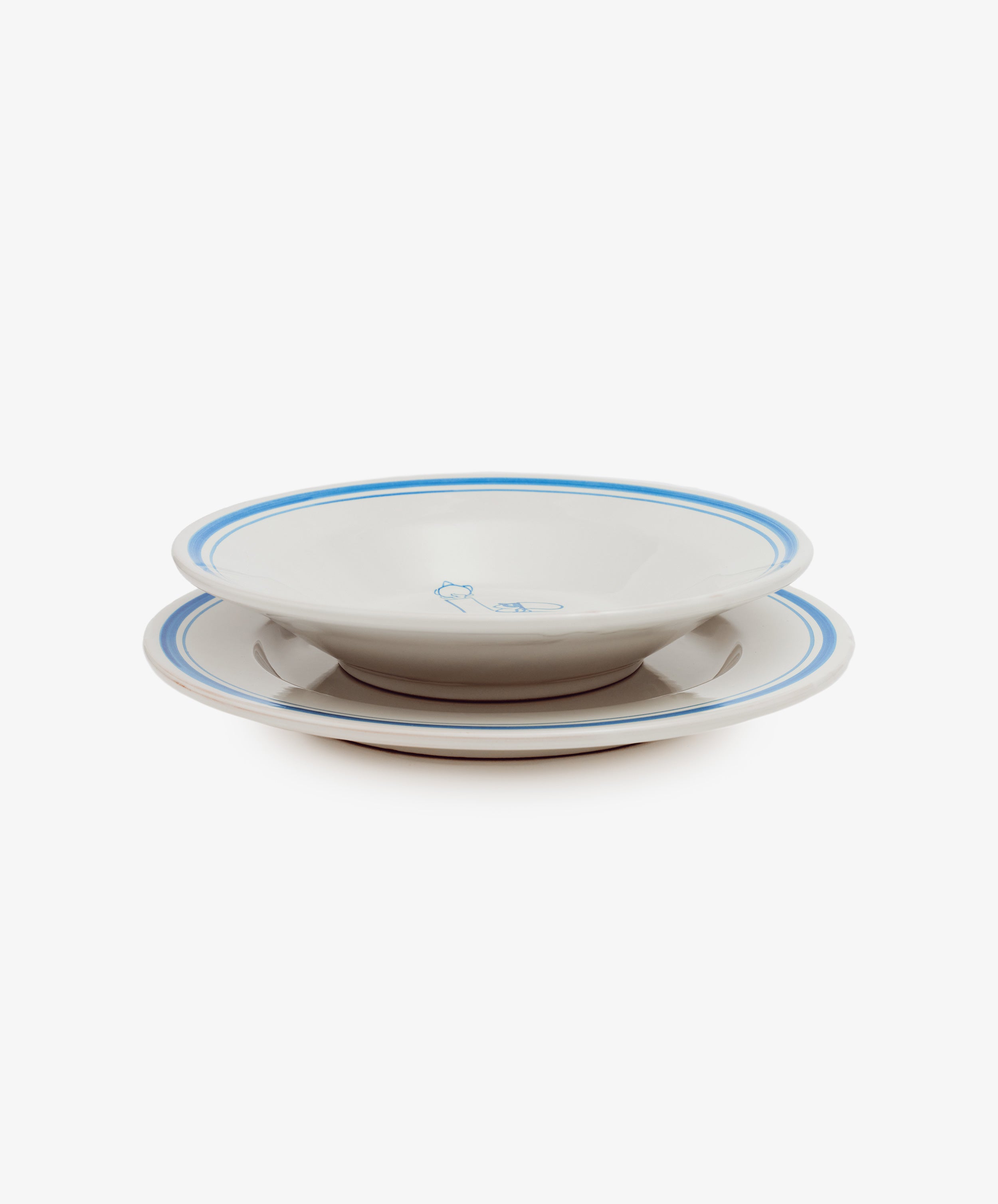Two Folk Dinner Plate, Jester—white ceramic plates with blue rims and a small central blue design, hand-painted by Italian ceramists—are stacked together against a plain white background.
