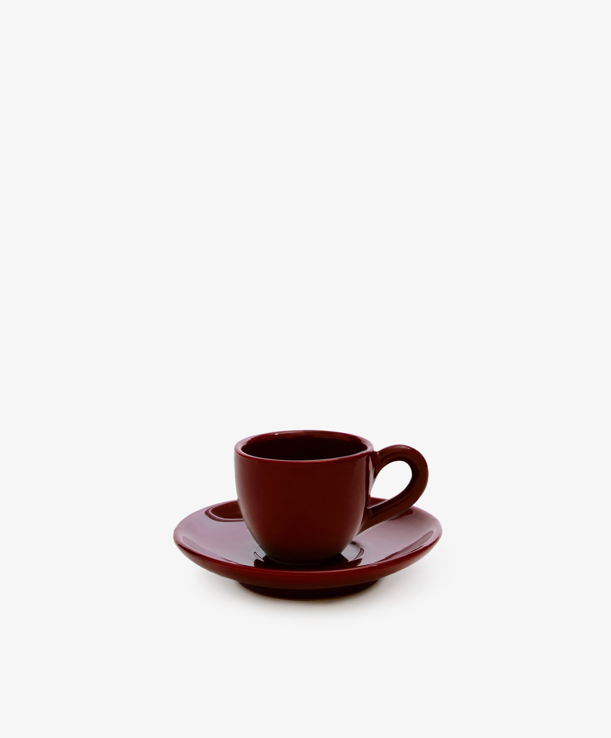 The Gio Espresso Set features a dark red handmade ceramic mug with a matching saucer, displayed against a plain white background.