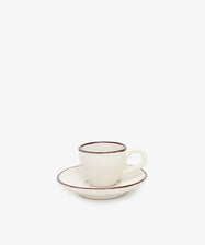 The Gio Espresso Set includes a handmade ceramic espresso cup with a handle and a matching saucer, both featuring brown trim, displayed against a plain white background.