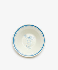 The Folk Pasta Bowl, Jester is a hand-glazed white ceramic bowl with a blue rim, featuring a simple blue line drawing of a dancing figure in the center—an elegant piece of Italian tableware.