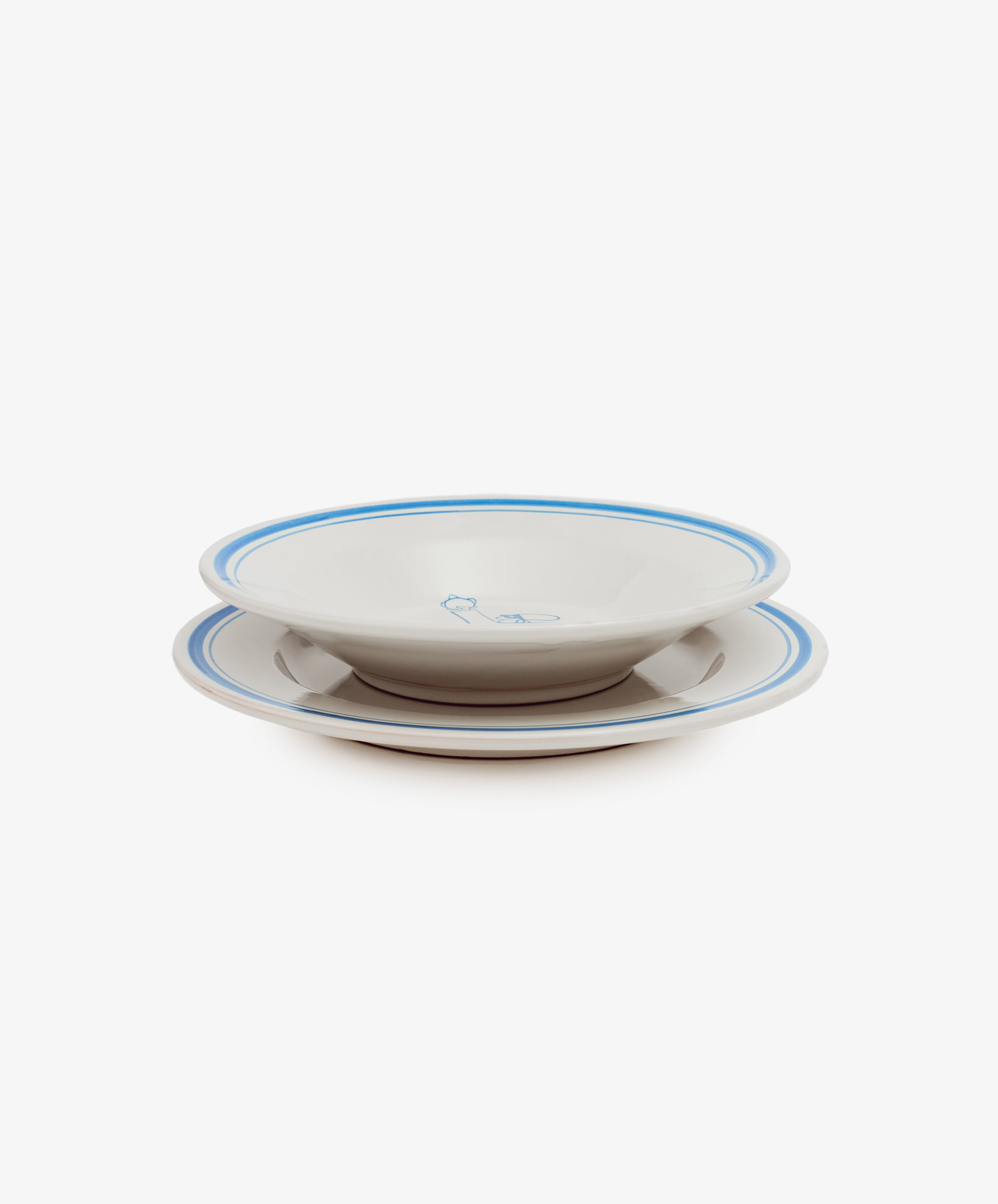 Two stacked Folk Pasta Bowls, Jester—white ceramic with blue rims and a central blue design—hand-glazed for a unique finish, shown against a white background.
