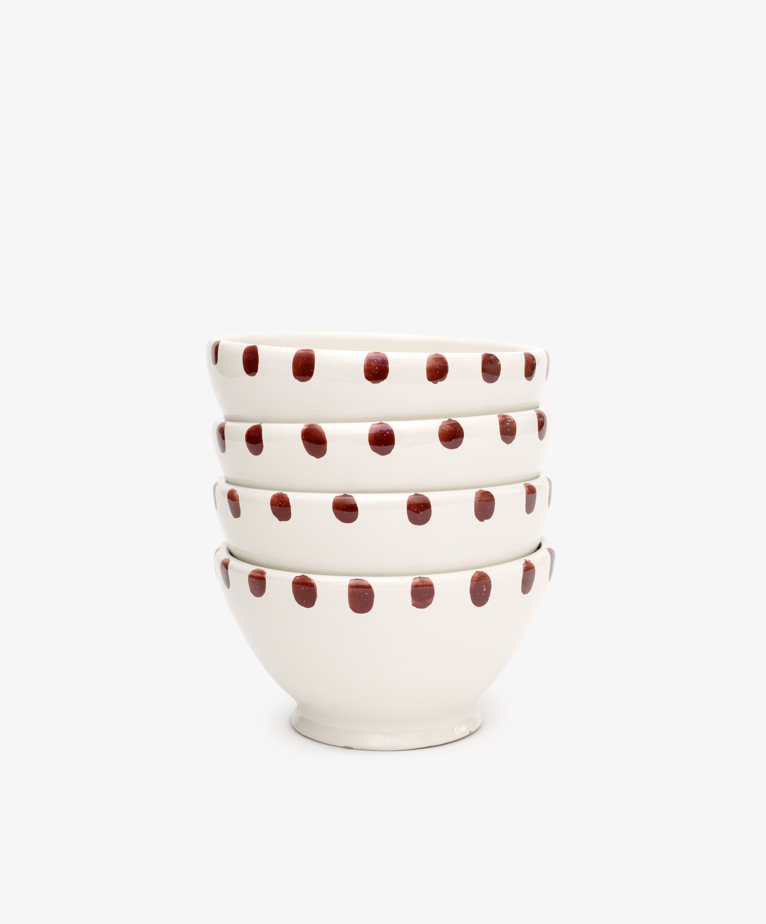 A set of four white Nina Bowls featuring red polka dots and dotted rims are stacked together against a plain white background.