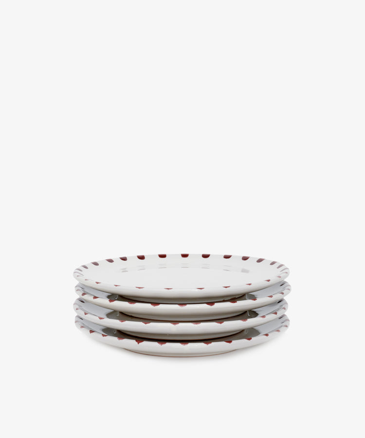 Stack of four white ceramic plates with burgundy accents.