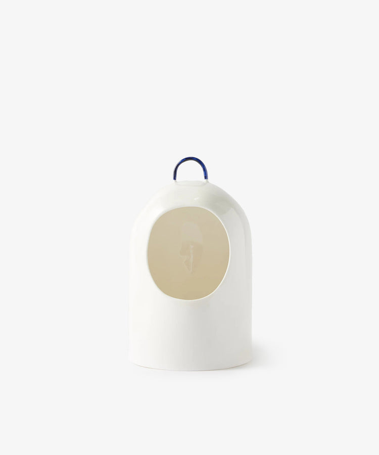 The Salt Pig is a white ceramic salt holder with a minimalist dome shape, circular opening, and a small blue handle on top, shown against a plain light background.