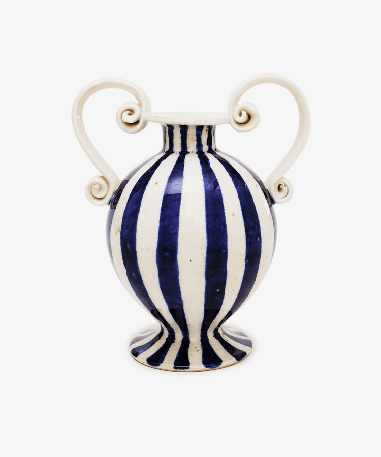 The Cyrene Bud Vase features hand-thrown craftsmanship, blue-and-white vertical stripes, and sculptural scroll handles, shown against a plain white background.