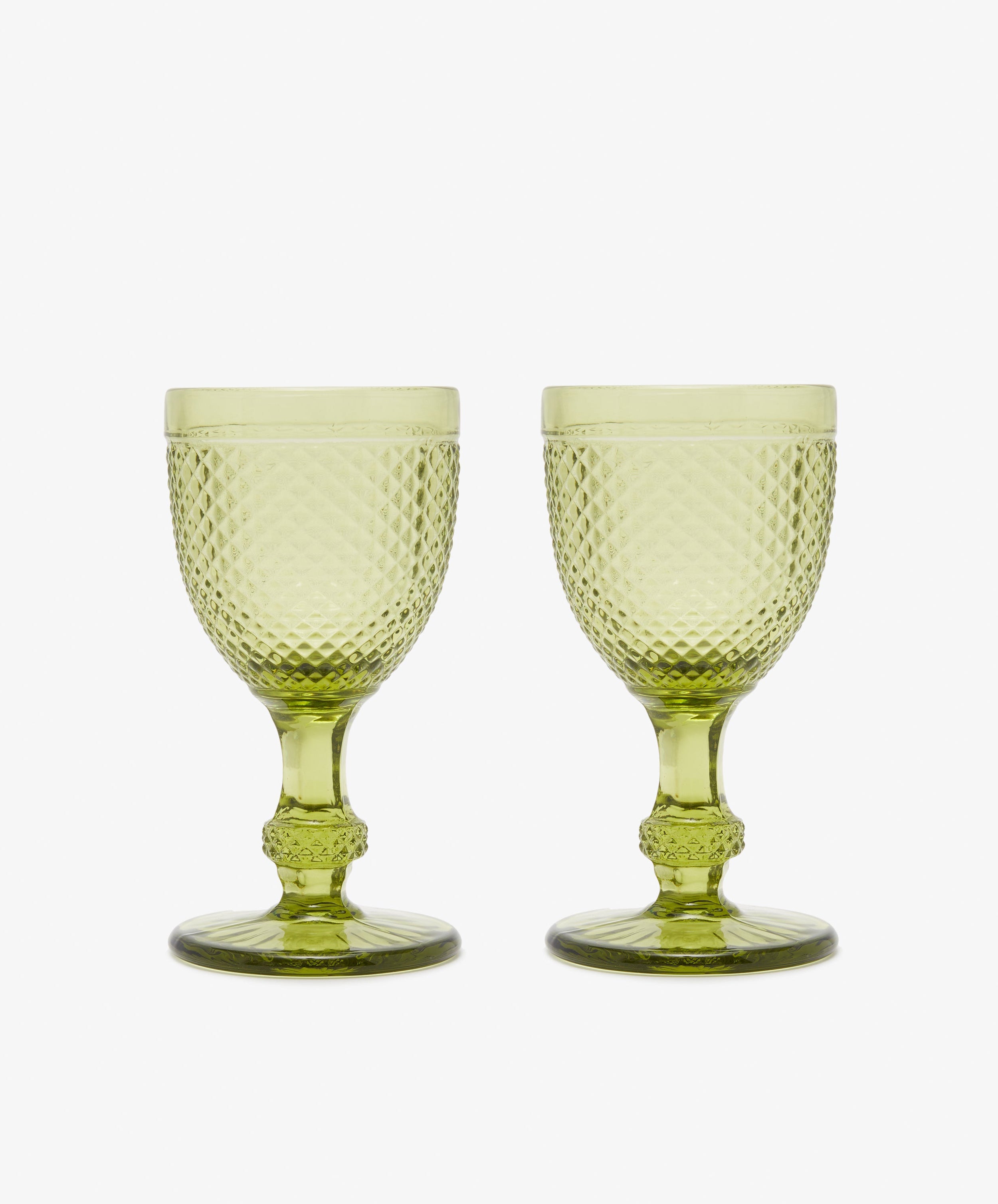 A set of six Celeste Red Wine Glasses, each with short stems and diamond-cut surfaces in subtle green, is displayed side by side on a white background.