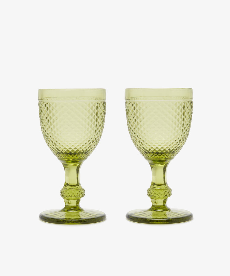 A set of six Celeste Red Wine Glasses, each with short stems and diamond-cut surfaces in subtle green, is displayed side by side on a white background.