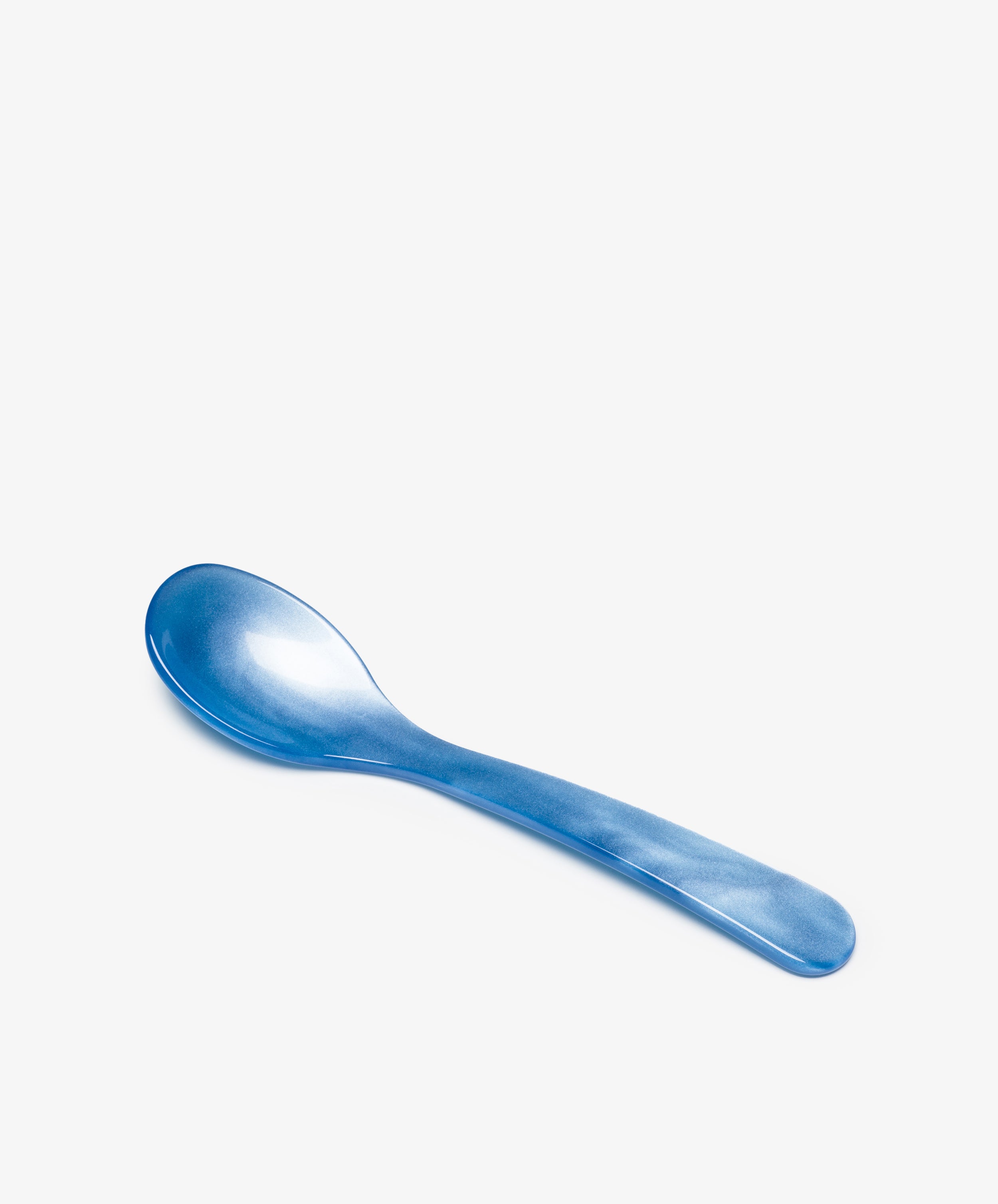 The Piccolo Spoon, made from blue acrylic with elegant craftsmanship, rests on a plain white background.