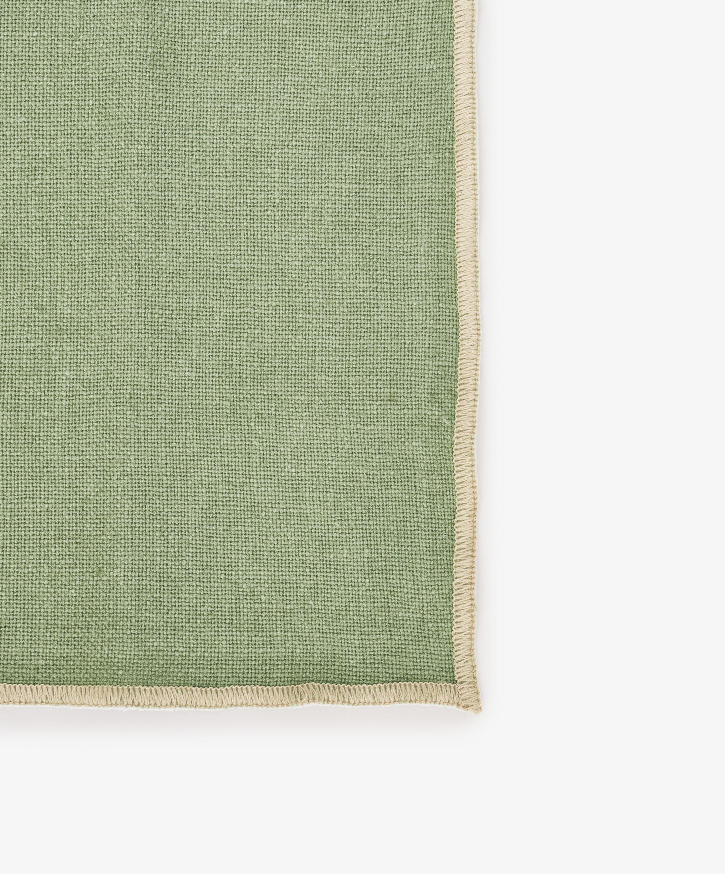 A close-up of the Corte Napkin, Set of 6, in green eco-friendly linen with beige stitched edges, set against a white background—ideal for adding elegance to your table as placemats or napkins.