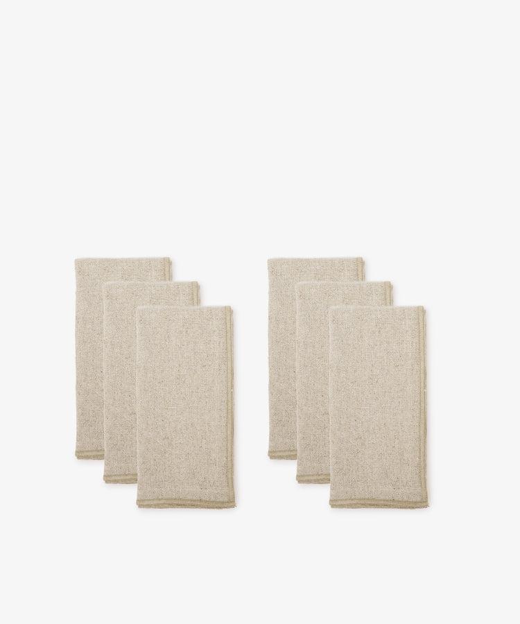 A set of six beige Corte Napkins, neatly folded and eco-friendly, is arranged in two groups against a plain white background.