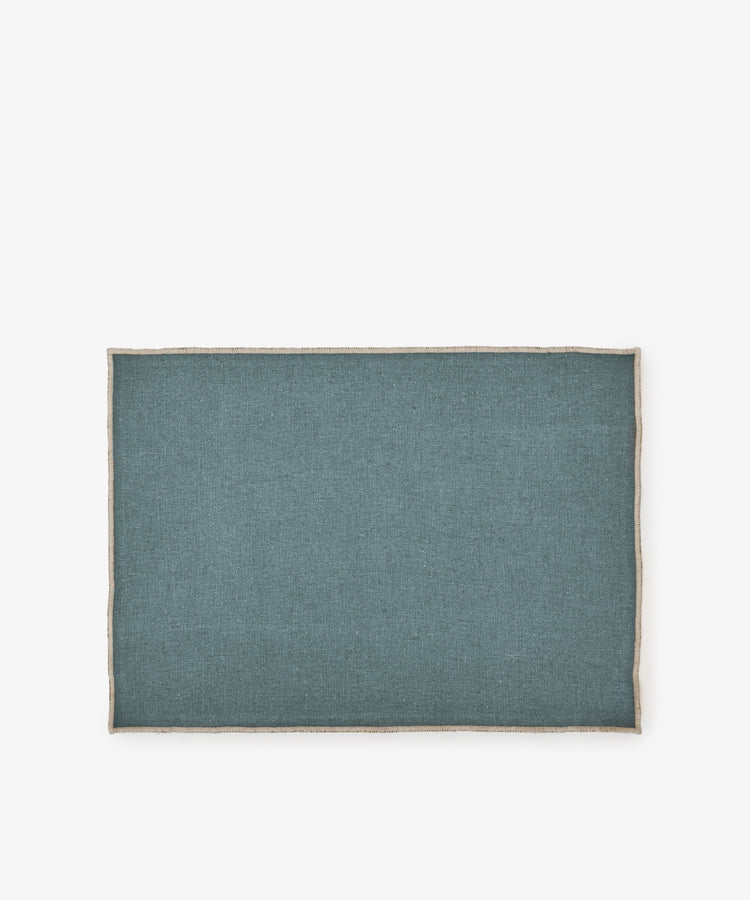 The Corte Placemat, Set of 6, features rectangular eco-friendly teal linen placemats with beige trim, shown on a white background.
