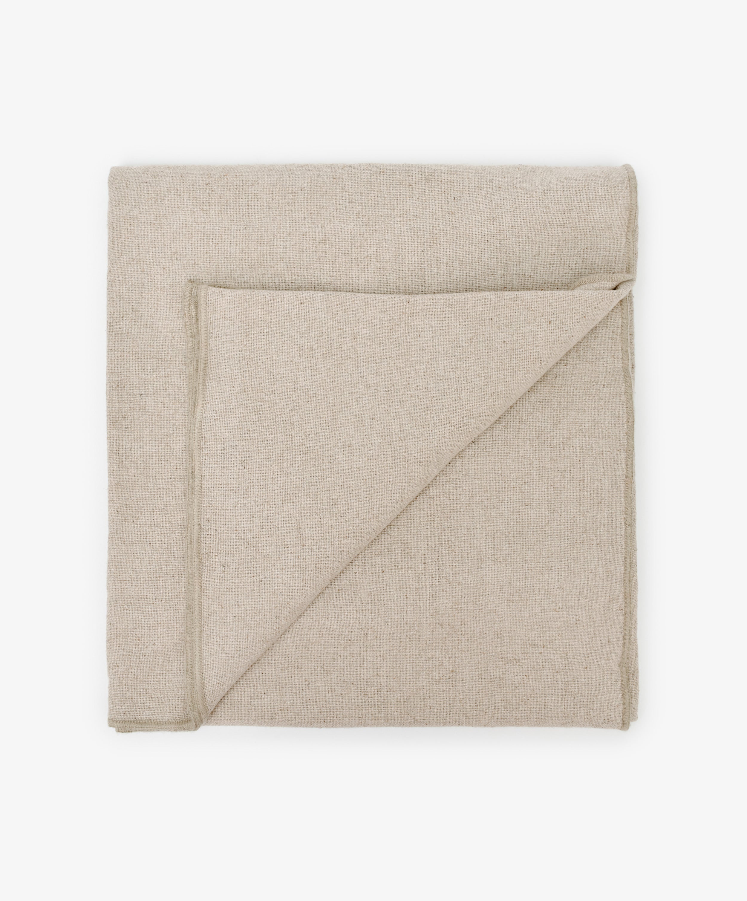 The Corte Tablecloth, neatly folded in beige linen with a corner turned down, is displayed on a white background.