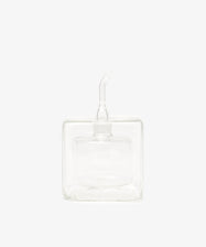 The Cube Oil & Vinegar Cruet features a clear glass, square body and short spout—ideal for any kitchen. Photographed on a plain white background.
