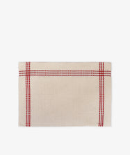 The Tilde Placemat, Set of 6, features a rectangular beige cloth with a textured surface and intersecting red and blue stripes near the edges, crafted in the classic Daldräll pattern—perfect for fans of authentic Swedish Insjöns fabric.