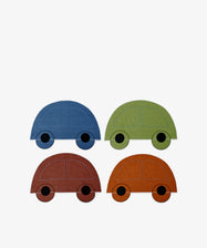 The Thomas Placemat Set of 4 features blue, green, brown, and orange paper cutout cars arranged in a two-by-two grid on white wipeable placemats—perfect for kids.