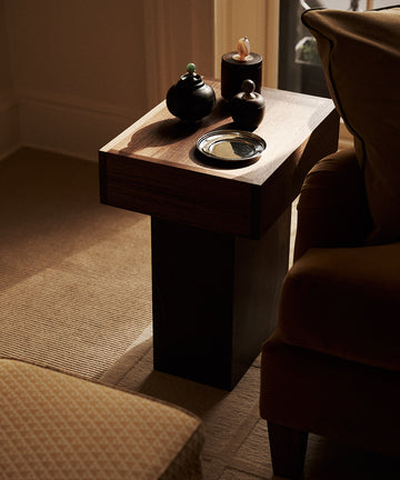 wood side table with wood boxes on it and a silver dish