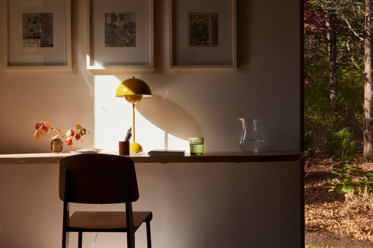 chair and desk with yellow lamp and big window with nature