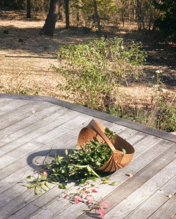 flowers in wood basket on porch outside