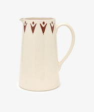 The Vito Jug is a cream-colored ceramic jug with a curved handle and a repeating brown geometric pattern at the top. Handmade, its an ideal unique gift for any occasion.